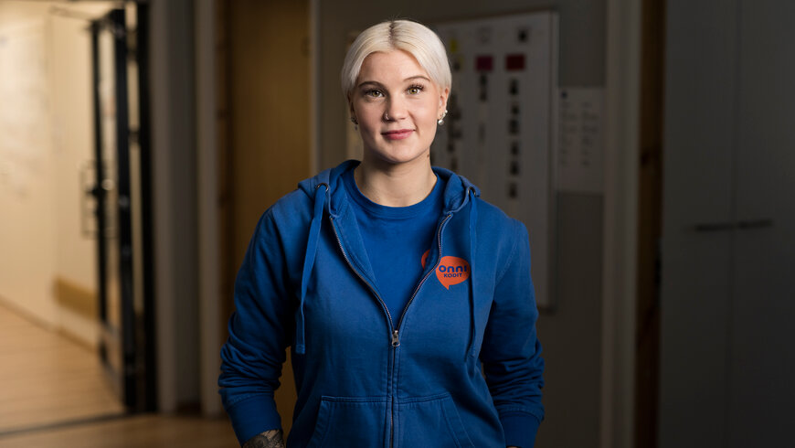 Onnikotien työntekijä seisoo asumisyksikön käytävällä.